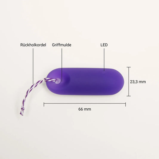 Technische Detailansicht des trackleCatch Sensors: Die lila, pillenförmige Hardware ist mit Maßen beschriftet (66 mm Länge, 23,3 mm Breite). Markierungen zeigen die Position der Rückholkordel, der Griffmulde für das einfache Entfernen und der integrierten LED-Anzeige.