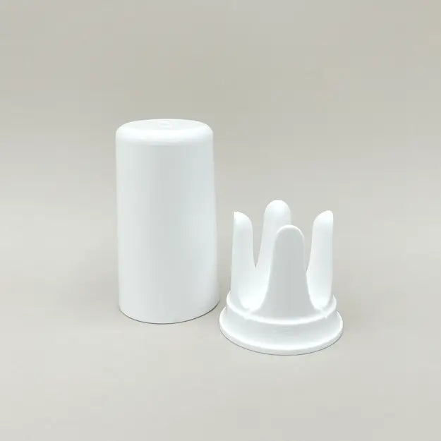 Weiße trackle Aufbewahrungsbox und Halterung für den trackle Sensor auf neutralem Hintergrund. Das Set besteht aus einem zylindrischen Deckel und der charakteristischen kronenförmigen Halterung, in die der Sensor zum Auslesen und Aufbewahren gesteckt wird.