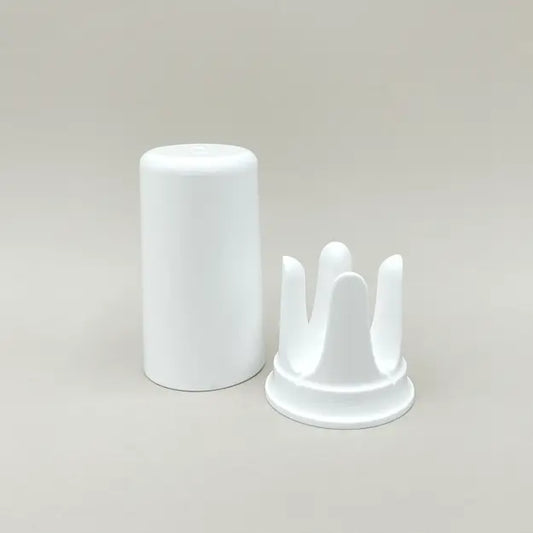 Weiße trackle Aufbewahrungsbox und Halterung für den trackle Sensor auf neutralem Hintergrund. Das Set besteht aus einem zylindrischen Deckel und der charakteristischen kronenförmigen Halterung, in die der Sensor zum Auslesen und Aufbewahren gesteckt wird.