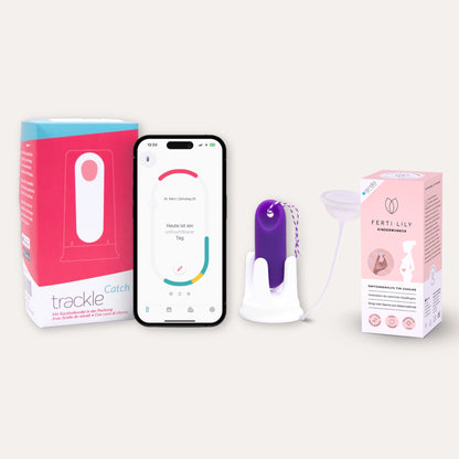 Produkt-Bundle für die Empfängnis: Das Bild stellt die trackleCatch Verpackung, ein Smartphone mit der trackle App (Anzeige eines unfruchtbaren Tages), den lila trackleCatch in seiner Halterung sowie die FERTI-LILY Empfängnishilfe mit der dazugehörigen rosa Verpackung dar. Ein komplettes System zur Bestimmung der fruchtbaren Tage und zur Unterstützung der natürlichen Befruchtung.