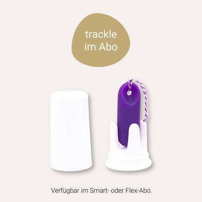 Infografik zum trackle Abo-Modell. Ein goldener Kreis zeigt den Text 'trackle im Abo'. Darunter ist der lila trackleCatch in seiner weißen Halterung neben der Schutzkappe abgebildet. Am unteren Rand steht der Hinweis: 'Verfügbar im Smart- oder Flex-Abo'.