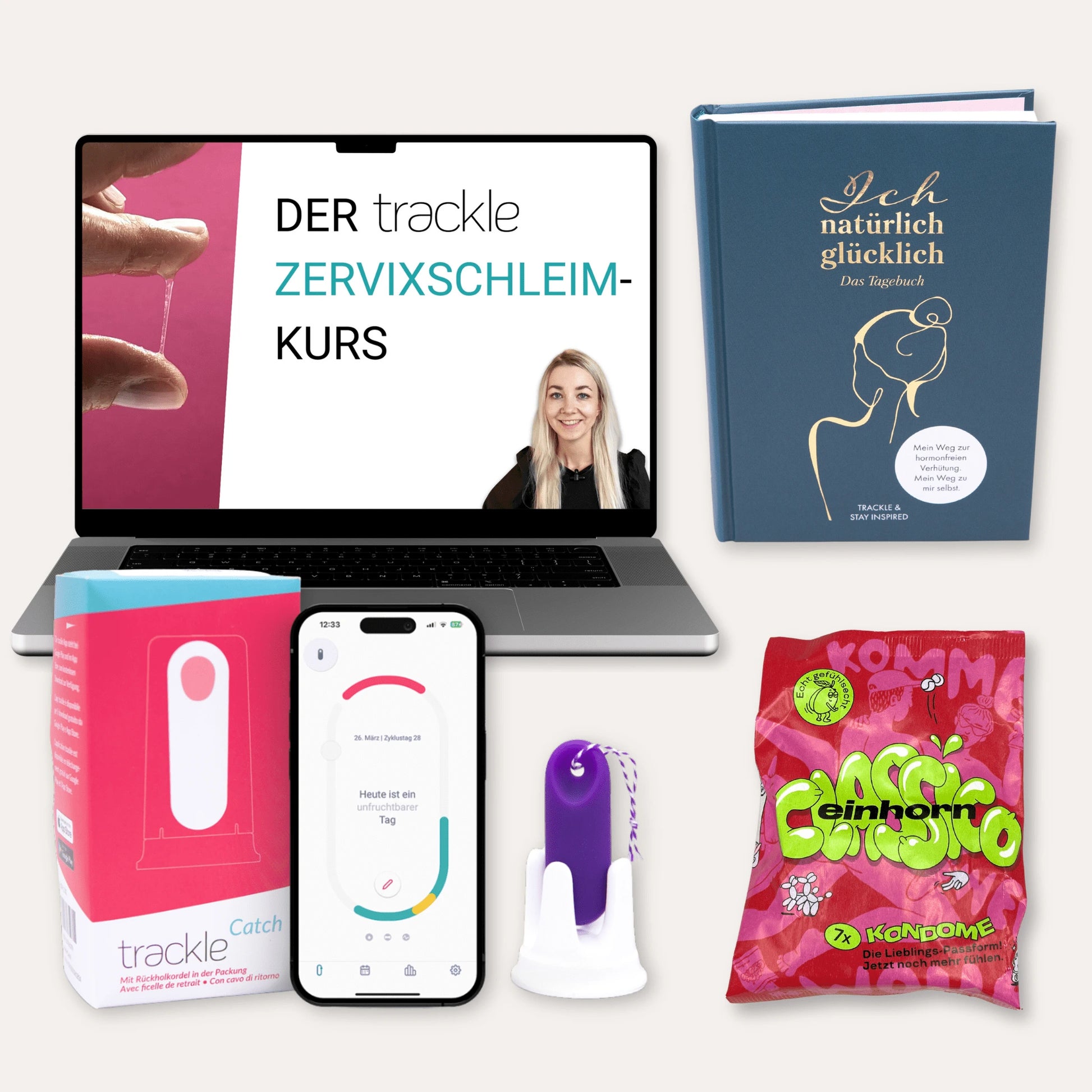 Produktübersicht für die hormonfreie Verhütung: Ein Laptop zeigt den 'trackle Zervixschleim-Kurs', daneben das Tagebuch 'Ich natürlich glücklich'. Im Vordergrund stehen die trackleCatch Verpackung, ein Smartphone mit der Zyklus-App (Anzeige: unfruchtbarer Tag), der lila trackleCatch in seiner Halterung und eine rote Packung einhorn 'Classico' Kondome.