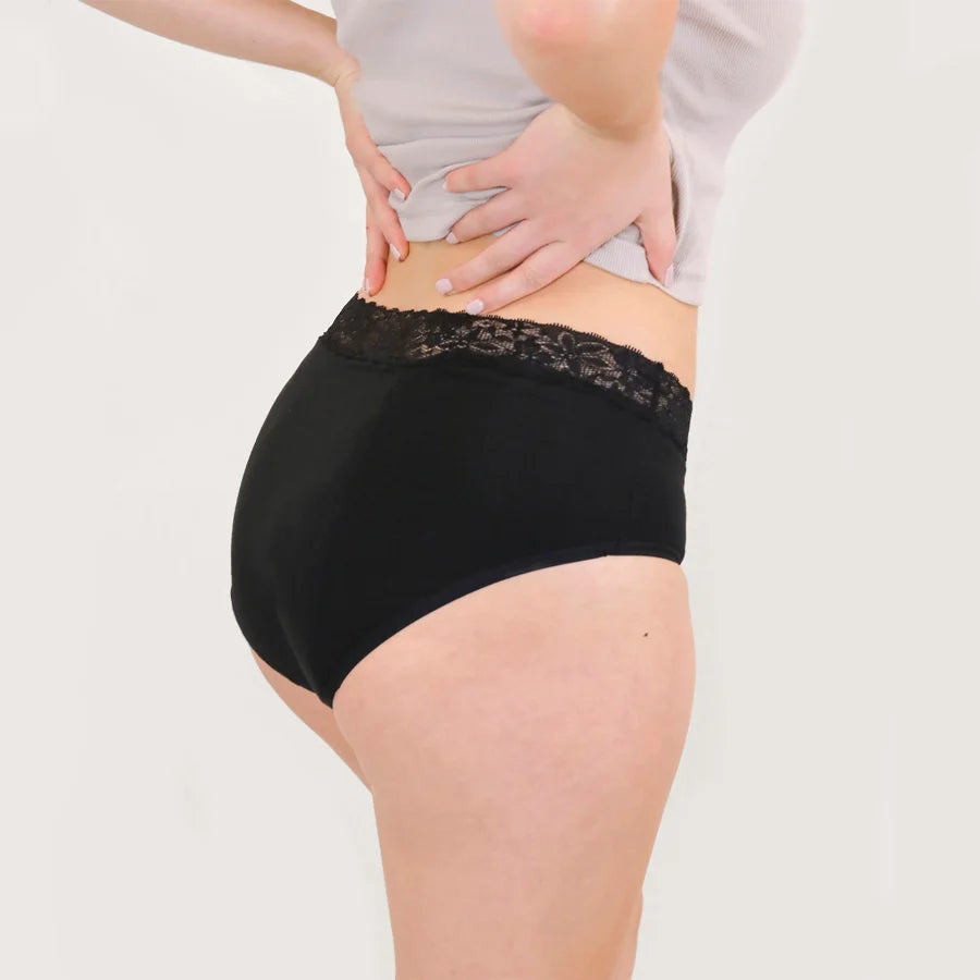 Rückansicht der Hipster Strong Periodenunterwäsche in Schwarz. Der Schnitt bietet eine sichere Abdeckung am Gesäß. Der Spitzenbund schließt bündig ab und sorgt für eine elegante Optik.