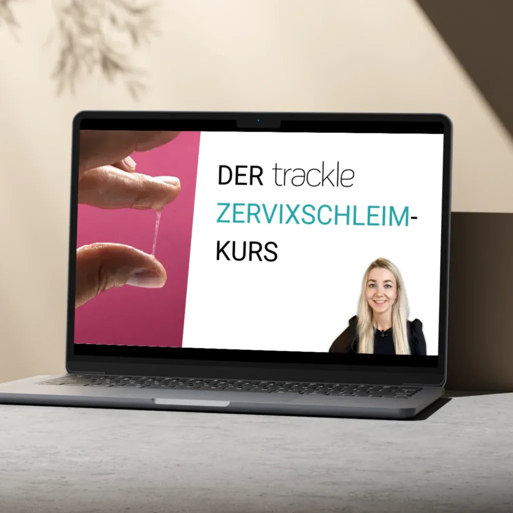 Ein Laptop auf einem grauen Tisch vor hellem Hintergrund zeigt den Startbildschirm des 'trackle Zervixschleim-Kurses'. Das Design enthält eine Nahaufnahme der Schleimprüfung und ein Porträt der Expertin.