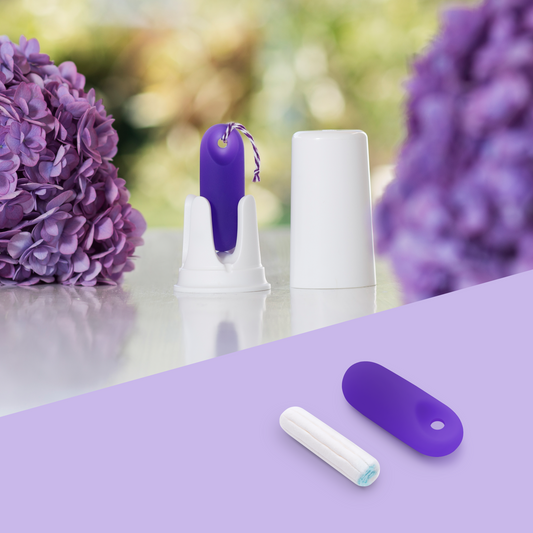 Zweigeteiltes Bild: Oben steht der lila trackleCatch in seiner weißen Halterung zwischen lila Hortensienblüten im Garten. Unten links liegt der lila Sensor zum Größenvergleich direkt neben einem herkömmlichen Tampon auf lila Hintergrund. Das Bild verdeutlicht die kompakte, anatomische Größe des Sensors.